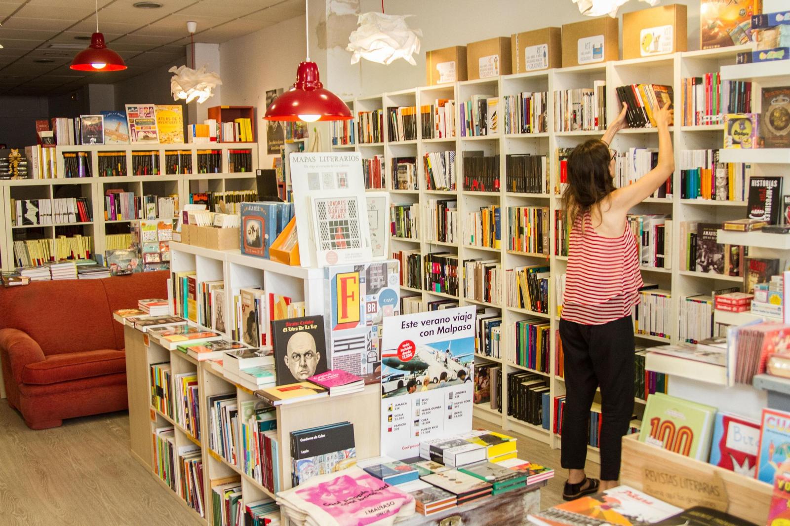 Vista de la librería-cafetería La Casa Tomada en Sevilla, con estantes llenos de libros y un ambiente acogedor